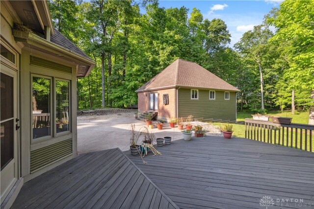 4384 New Market Banta Rd, Lewisburg, OH 45338 - wooden deck featuring a patio area, an outdoor structure, view of scattered trees, and a lawn