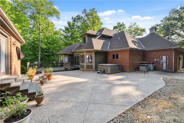 4384 New Market Banta Rd, Lewisburg, OH 45338 - back of property with a hot tub, a patio, roof with shingles, brick siding, and a chimney