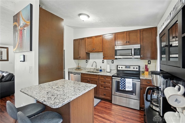 9675 Pellston Way, Miamisburg, OH 45342 - kitchen featuring stainless steel appliances, a sink, vaulted ceiling, backsplash, and dark wood-style flooring