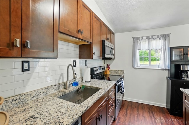 9675 Pellston Way, Miamisburg, OH 45342 - kitchen with stainless steel appliances, a sink, baseboards, light stone counters, and dark wood finished floors
