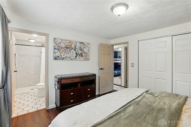 9675 Pellston Way, Miamisburg, OH 45342 - bedroom with a closet, dark wood-type flooring, ensuite bathroom, and a textured ceiling
