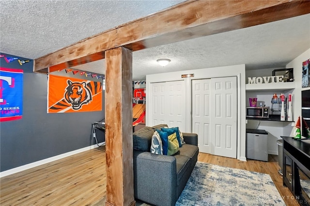 9675 Pellston Way, Miamisburg, OH 45342 - living area featuring a textured ceiling, wood finished floors, baseboards, and beam ceiling