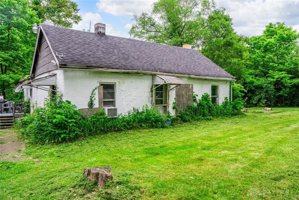 7657 Sharts Rd, Springboro, OH 45066 - view of side of home with roof with shingles, a chimney, a lawn, and a deck