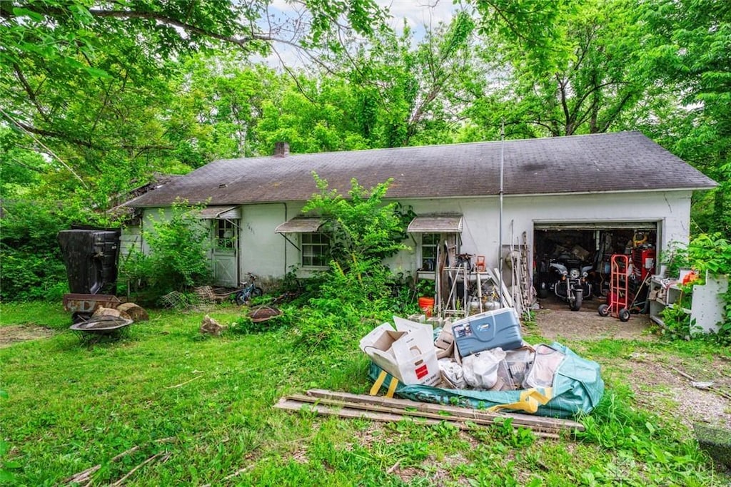 7657 Sharts Rd, Springboro, OH 45066 - rear view of house with a garage, a shingled roof, and a chimney