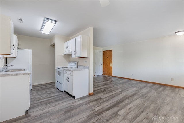 2648 Parklawn Dr, Kettering, OH 45440 - kitchen with electric range, under cabinet range hood, a sink, and light wood-style flooring