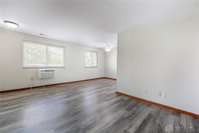 2648 Parklawn Dr, Kettering, OH 45440 - empty room with an AC wall unit, baseboards, wood finished floors, and a ceiling fan