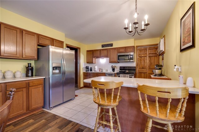 3726 Shawnee Trl, New Jasper Twp, OH 45335 - kitchen with stainless steel appliances, a kitchen breakfast bar, light countertops, brown cabinets, and a peninsula