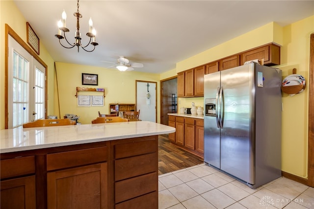 3726 Shawnee Trl, New Jasper Twp, OH 45335 - kitchen with stainless steel fridge, brown cabinets, a chandelier, ceiling fan, and light tile patterned floors