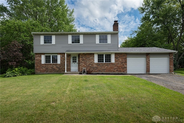 2547 Ryan Ct, Beavercreek, OH 45434 - colonial house featuring a chimney, brick siding, an attached garage, asphalt driveway, and a front lawn