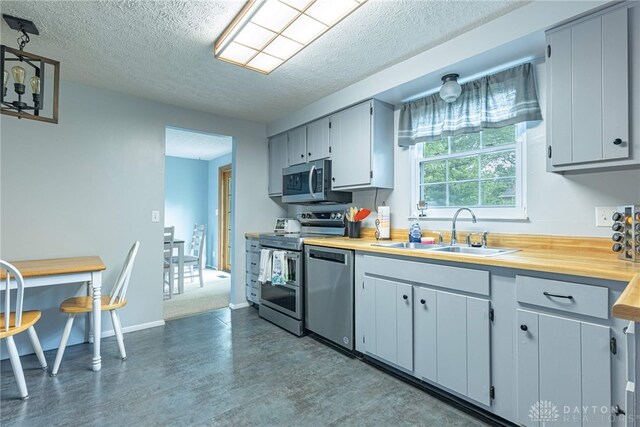 2547 Ryan Ct, Beavercreek, OH 45434 - kitchen with a sink, stainless steel appliances, a textured ceiling, dark wood-style floors, and baseboards