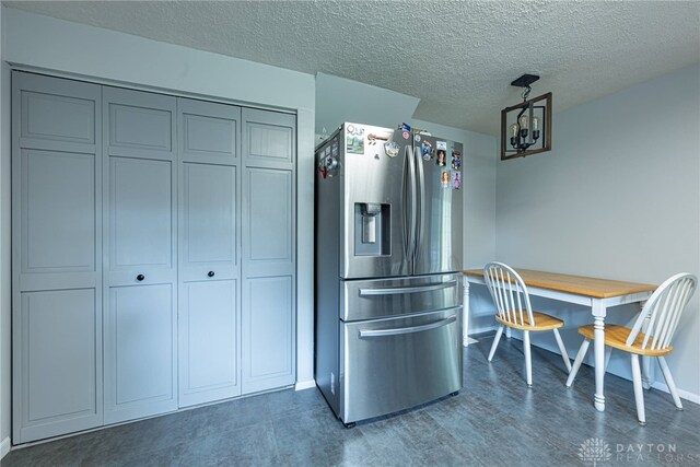 2547 Ryan Ct, Beavercreek, OH 45434 - kitchen featuring stainless steel fridge, baseboards, a chandelier, a textured ceiling, and wood finished floors
