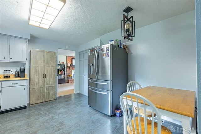 2547 Ryan Ct, Beavercreek, OH 45434 - kitchen featuring stainless steel refrigerator with ice dispenser, a textured ceiling, light countertops, white cabinetry, and wood finished floors