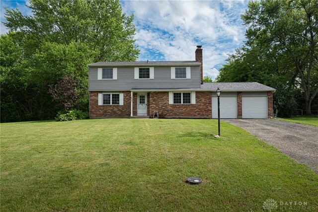 2547 Ryan Ct, Beavercreek, OH 45434 - colonial inspired home with a chimney, an attached garage, brick siding, and driveway