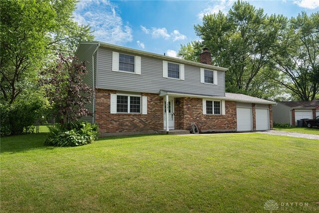 2547 Ryan Ct, Beavercreek, OH 45434 - view of front of home with a chimney, asphalt driveway, an attached garage, brick siding, and a front yard