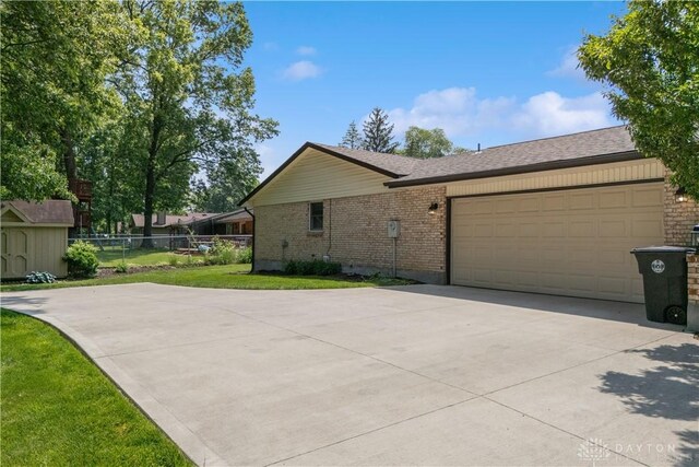 560 Roselake Dr, Centerville, OH 45458 - view of side of home featuring brick siding, concrete driveway, and an attached garage