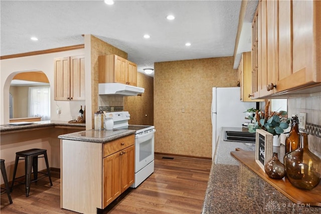 560 Roselake Dr, Centerville, OH 45458 - kitchen with white appliances, under cabinet range hood, wood finished floors, arched walkways, and baseboards