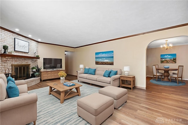 560 Roselake Dr, Centerville, OH 45458 - living area featuring a chandelier, arched walkways, light wood-style flooring, a brick fireplace, and recessed lighting