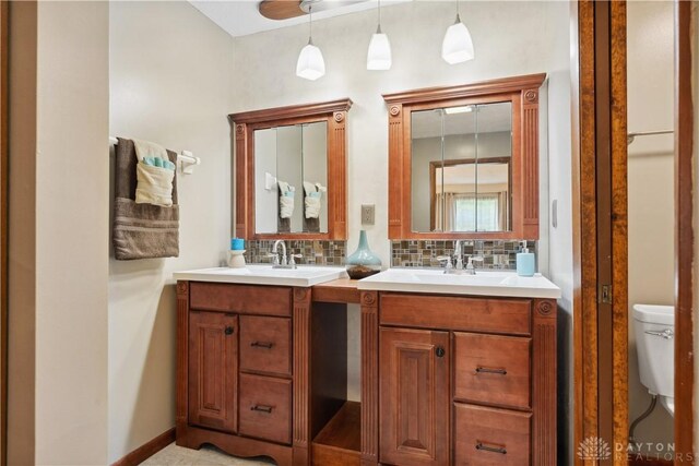 560 Roselake Dr, Centerville, OH 45458 - full bathroom with backsplash, vanity, toilet, and baseboards