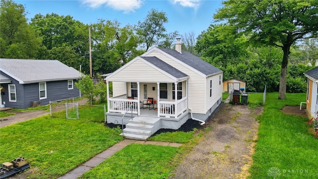 2755 S Blvd, Dayton, OH 45419 - view of front of house featuring a shed, covered porch, a chimney, asphalt driveway, and a front lawn