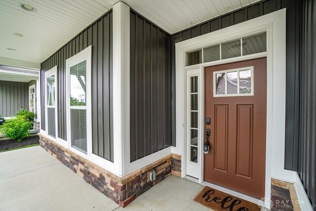 5053 Maiden Way, Liberty Twp, OH 45011 - property entrance featuring covered porch, board and batten siding, and stone siding