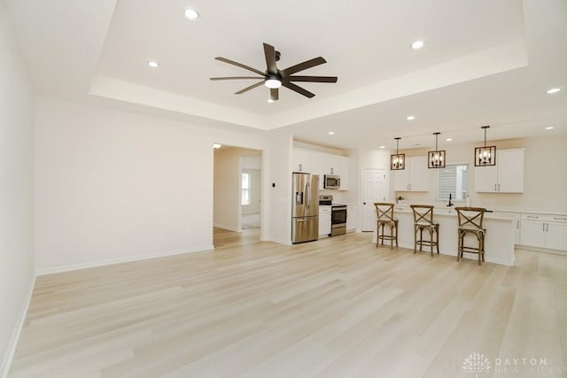5053 Maiden Way, Liberty Twp, OH 45011 - living area featuring a raised ceiling, ceiling fan, light wood-type flooring, recessed lighting, and baseboards
