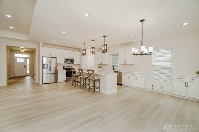 5053 Maiden Way, Liberty Twp, OH 45011 - kitchen with stainless steel appliances, a chandelier, light wood-style floors, a kitchen bar, and recessed lighting