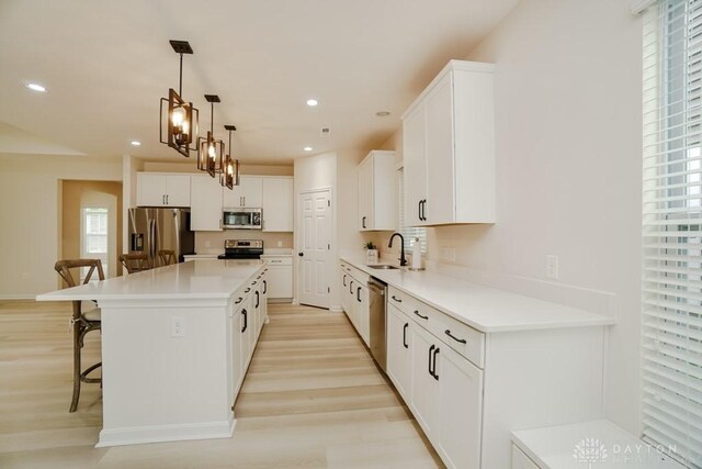 5053 Maiden Way, Liberty Twp, OH 45011 - kitchen featuring stainless steel appliances, a kitchen bar, a center island, light wood-style flooring, and white cabinetry