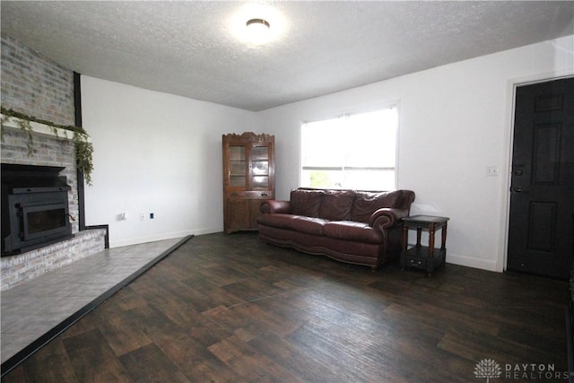 6959 Edenton Pleasant Plain Rd, Wayne Twp, OH 45162 - living room featuring wood finished floors, a textured ceiling, a brick fireplace, and baseboards