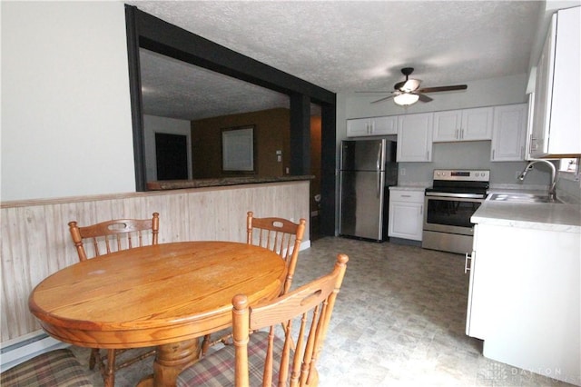 6959 Edenton Pleasant Plain Rd, Wayne Twp, OH 45162 - dining space featuring ceiling fan, light flooring, a wainscoted wall, a textured ceiling, and a baseboard heating unit