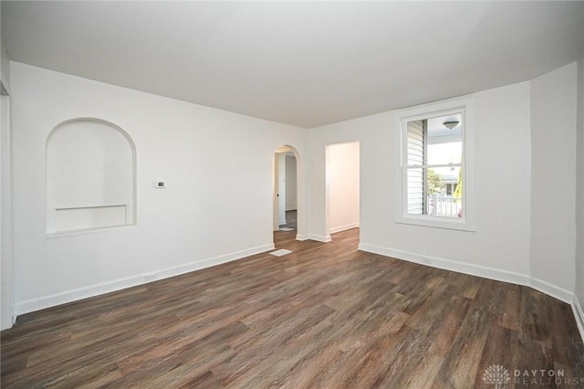 4612 Ward St, Cincinnati, OH 45227 - unfurnished room featuring dark wood-style flooring, arched walkways, and baseboards