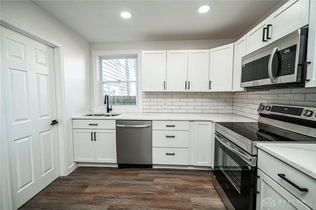 4612 Ward St, Cincinnati, OH 45227 - kitchen featuring appliances with stainless steel finishes, a sink, backsplash, dark wood finished floors, and recessed lighting
