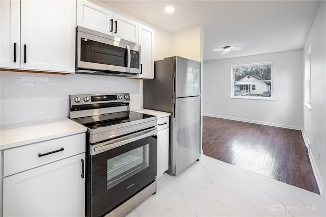 6417 Bramble Ave, Cincinnati, OH 45227 - kitchen featuring appliances with stainless steel finishes, white cabinetry, backsplash, light countertops, and baseboards