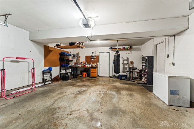 340 Marsha Jeanne Way, Dayton, OH 45458 - garage with fridge, a garage door opener, and a workshop area