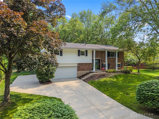 340 Marsha Jeanne Way, Dayton, OH 45458 - split foyer home featuring concrete driveway, brick siding, a garage, and a front lawn