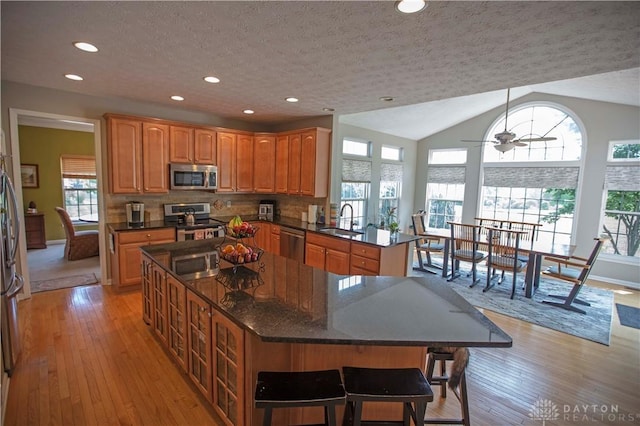 4560 James Madison Trl, Kettering, OH 45440 - kitchen featuring appliances with stainless steel finishes, a sink, a kitchen island, plenty of natural light, and a textured ceiling