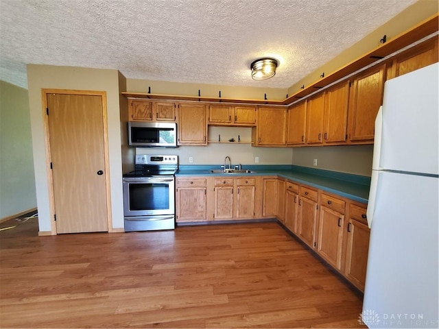 1261 Dusty Ln, West Alexandria, OH 45381 - kitchen featuring stainless steel appliances, a textured ceiling, light wood-type flooring, open shelves, and a sink