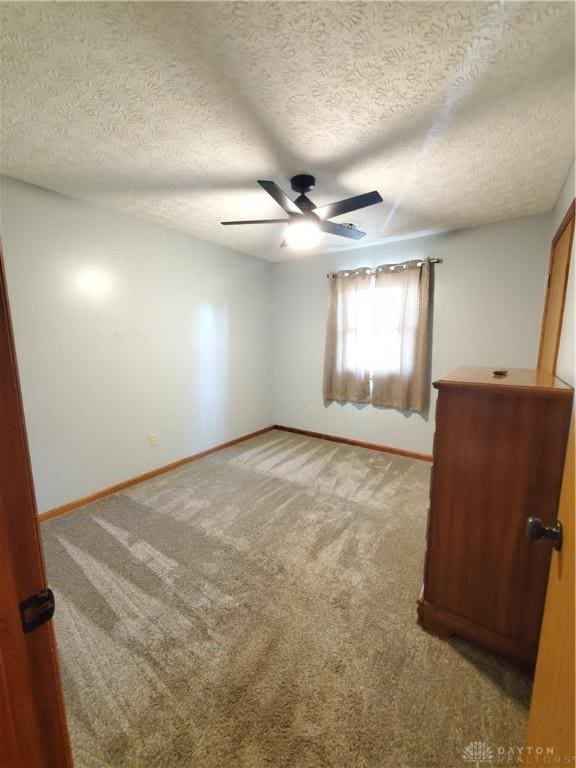 1261 Dusty Ln, West Alexandria, OH 45381 - spare room featuring ceiling fan, baseboards, light carpet, and a textured ceiling