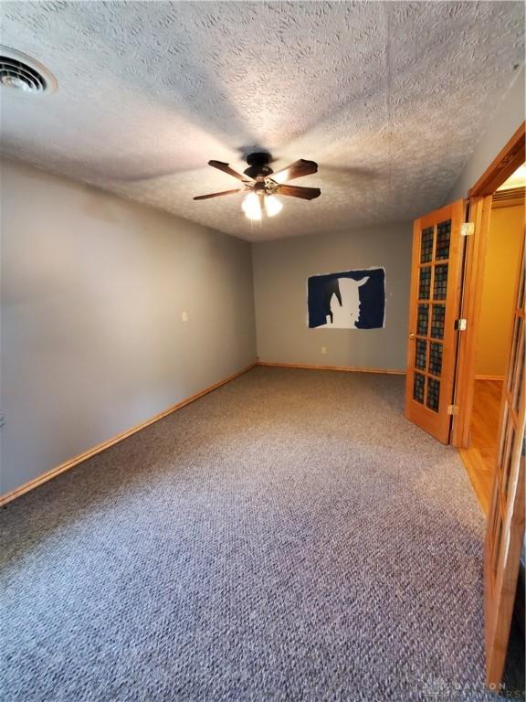 1261 Dusty Ln, West Alexandria, OH 45381 - carpeted spare room featuring a ceiling fan, baseboards, and a textured ceiling