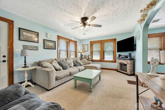 4975 Hamilton Eaton Rd, Hamilton, OH 45013 - carpeted living room with a ceiling fan, baseboards, a textured ceiling, a fireplace, and arched walkways