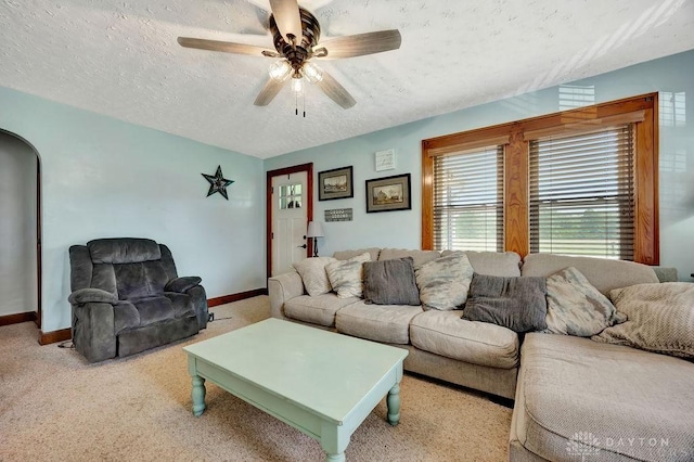 4975 Hamilton Eaton Rd, Hamilton, OH 45013 - living room featuring a textured ceiling, baseboards, arched walkways, a ceiling fan, and carpet flooring