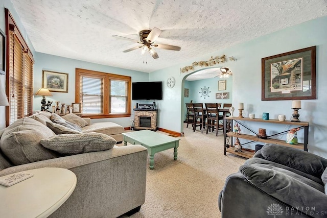 4975 Hamilton Eaton Rd, Hamilton, OH 45013 - carpeted living area with a ceiling fan, a textured ceiling, arched walkways, a fireplace, and baseboards