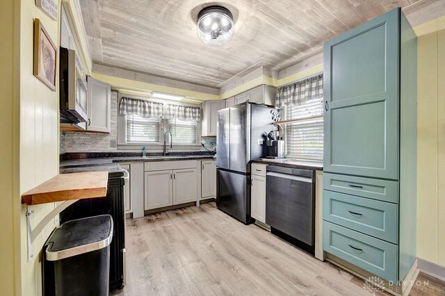 4975 Hamilton Eaton Rd, Hamilton, OH 45013 - kitchen with appliances with stainless steel finishes, a sink, light wood-style flooring, decorative backsplash, and green cabinetry