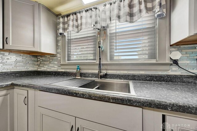 4975 Hamilton Eaton Rd, Hamilton, OH 45013 - kitchen with dark countertops, a sink, and decorative backsplash