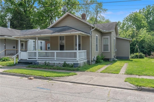 282 S W St, Xenia, OH 45385 - view of front of house with covered porch, a chimney, a front lawn, and a shingled roof