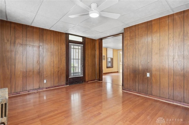 282 S W St, Xenia, OH 45385 - unfurnished room with wood finished floors, wood walls, a ceiling fan, a drop ceiling, and baseboards