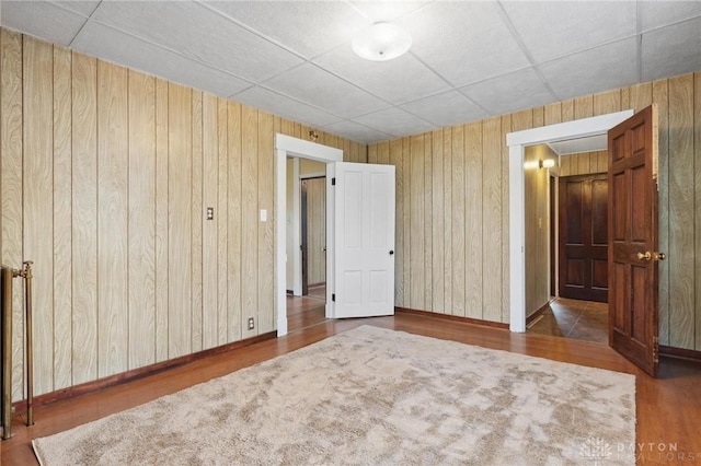 282 S W St, Xenia, OH 45385 - unfurnished bedroom with wood walls, wood finished floors, baseboards, and a paneled ceiling