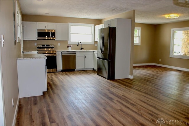5317 Plainfield Rd, Dayton, OH 45432 - kitchen featuring stainless steel appliances, plenty of natural light, baseboards, light countertops, and a textured ceiling