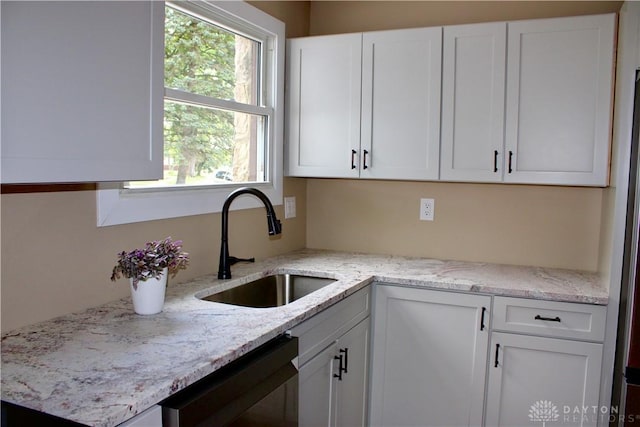 5317 Plainfield Rd, Dayton, OH 45432 - kitchen featuring a sink, white cabinetry, dishwashing machine, and light stone counters
