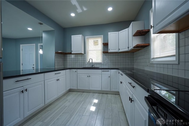 3409 E 5th St, Dayton, OH 45403 - kitchen with open shelves, a sink, range, dark countertops, and white cabinetry