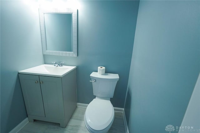 3409 E 5th St, Dayton, OH 45403 - half bath with vanity, toilet, baseboards, and marble finish floors